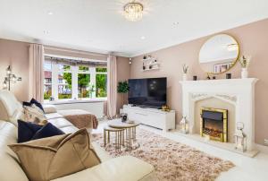 a living room with a fireplace and a tv at Spacious 4BR with Parking for Groups & Contractors in Solihull