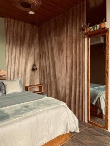 a bedroom with a large bed and a mirror at Palmar el descanso bruma del balsal in Villeta +13 photos