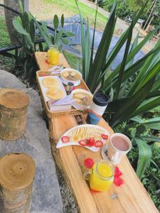a wooden table with breakfast foods and drinks on it at Palmar el descanso bruma del balsal in Villeta