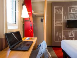 a laptop computer sitting on a desk in a room at ibis Saint-Omer Centre in Saint-Omer