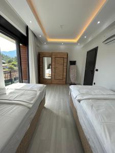 two beds in a room with a large window at Tekirova DOM Villas with Heated Pool in Kemer +16 photos