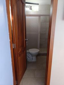 a bathroom with a toilet and a door open at Hospedaje Carigan in Loja