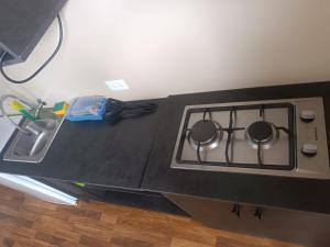 a kitchen counter with a stove and a sink at Hospedaje Carigan in Loja