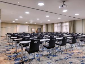 a conference room with tables and chairs and a whiteboard at Mercure Hotel Duisburg City in Duisburg +66 photos