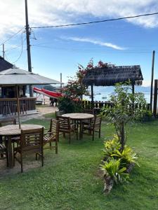 a group of tables and benches in the grass at MAMBEMBE hostel - Ilha Grande, Vila do Abraão in Abraão