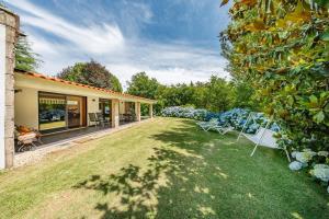 a house with a yard with two chairs on the grass at Casa do Rego - by Proguest in Valdosende