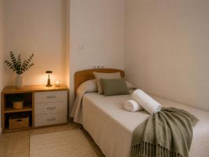 a bedroom with a bed and a nightstand with towels at Garbinada in Gandesa