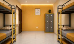 a room with three bunk beds and a yellow wall at Homies Homestay Boys Hostel in Kurukshetra +1 photo