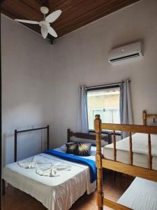 two beds in a room with a ceiling fan at POUSO DO BEIJA FLOR in Paraty +19 photos