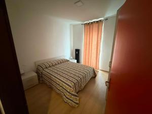 a small bedroom with a bed and a window at Casa Lina in Cavalese