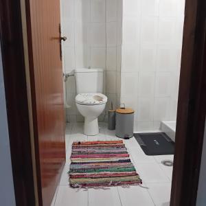 a bathroom with a toilet and a rug on the floor at Family garden house in Limenas