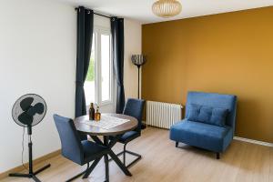 a room with a table and chairs and a window at Ma Bulle Confort in Pouzauges