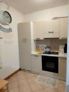a kitchen with a stove and a white refrigerator at Pretty home near station & Free Parking in Castel Bolognese +6 photos