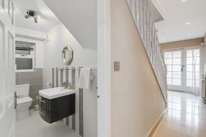 a white bathroom with a sink and a toilet at Spacious 4BR with Parking for Groups & Contractors in Solihull +79 photos