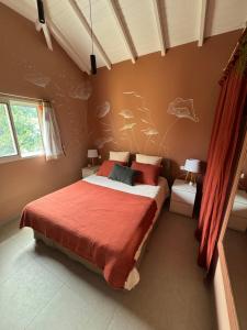 a bedroom with a bed with a red bedspread at Villa JAUNE in Oyster Pond +25 photos