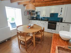 a kitchen with a wooden table and chairs in it at Pegs in Porthleven