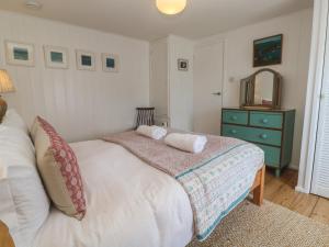 a bedroom with a bed with a dresser and a mirror at Pegs in Porthleven