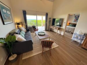 a living room with a couch and a tv at Villa JAUNE in Oyster Pond
