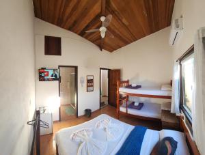 a bedroom with two beds and a ceiling fan at POUSO DO BEIJA FLOR in Paraty