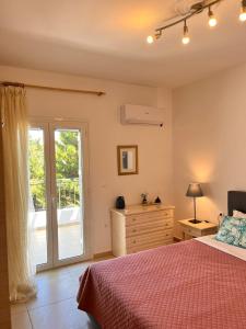 a bedroom with a bed and a sliding glass door at Lakithra Apartments in Kefallonia
