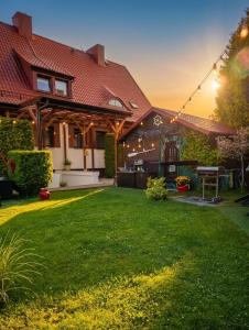 a house with a yard with green grass at PROMYK - Apartamenty & Pokoje - dla dorosłych in Białogóra