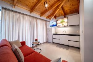 a living room with a red couch and a kitchen at Crown Villa in Sarandë