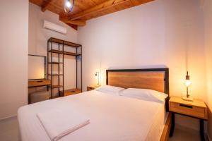 a bedroom with a large white bed and a television at Crown Villa in Sarandë