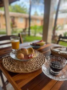 a table with a plate of food and a glass of orange juice at Pousada Marúa Fortaleza in Fortaleza