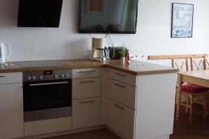 a kitchen with a stove top oven next to a table at Nordnordwest in Langeoog