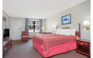 a hotel room with a bed and a television at A Red Dot Inn Milledgeville in Milledgeville