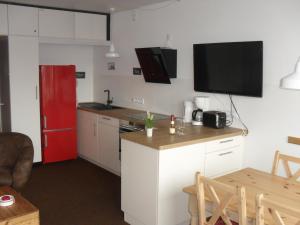 a small kitchen with a red refrigerator and a table at Nordnordwest in Langeoog