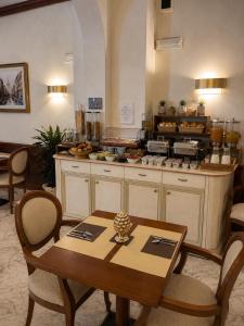 eine Küche mit einem Tisch und einer Theke mit Essen in der Unterkunft Hotel Posta in Cecina