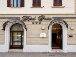 ein Ladenlokal mit zwei gewölbten Eingangstüren in der Unterkunft Hotel Posta in Cecina