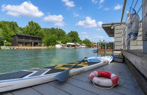 a raft and a paddle boat on a dock at Sunset view Housboat with sundeck,AC&Heating in Bratislava