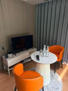 a living room with a table and two orange chairs at ZEVS-Holiday Complex in Deu