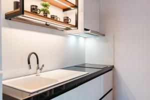 a kitchen with a sink and a mirror at Crown Villa in Sarandë +47 photos