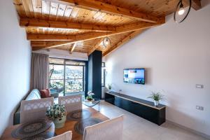 a living room with a wooden ceiling and a table at Crown Villa in Sarandë