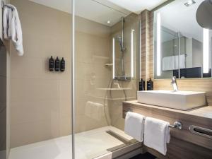 a bathroom with a sink and a shower at Mercure Salzburg City in Salzburg