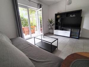 a living room with a couch and a television at Holiday home I.D.A. in Banjole