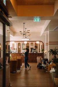 a person walking through a room with a restaurant at The Hoxton, Shepherds Bush in London