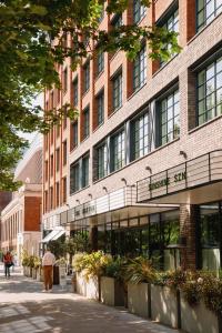 a man walking down a street in front of a building at The Hoxton, Shepherds Bush in London
