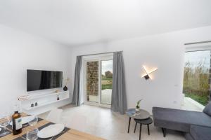 a living room with a couch and a tv at Naxos Cube Villa Panoramic Views Maisonette with Sea View 2 min walk to Plaka Beach in Plaka