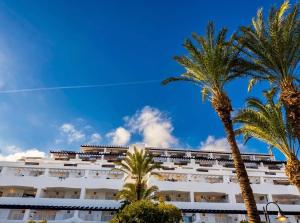 a white building with palm trees in front of it at Heavenly Homes Mojacar 75 in Mojácar