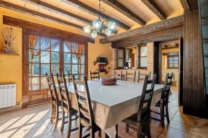 a kitchen and dining room with a table and chairs at Masia Puigadoll in Rodonyà