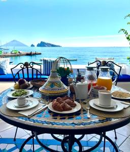 Ein Tisch mit Speisen darauf und Blick auf das Meer in der Unterkunft Hotel Tesoriero in Panarea