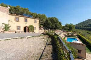 an external view of a house and a swimming pool at Masia Puigadoll in Rodonyà