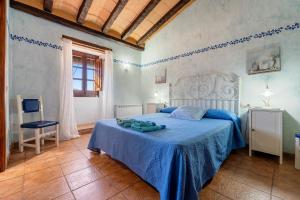 a bedroom with a blue bed with a blue blanket at Masia Puigadoll in Rodonyà +33 photos