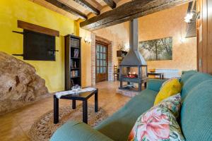 a living room with a couch and a fireplace at Masia Puigadoll in Rodonyà