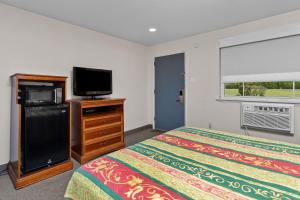 a bedroom with a bed and a flat screen tv at Village Lodge in Bristol