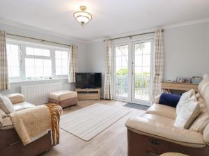 a living room with a couch and a tv at Seaward in Norwich